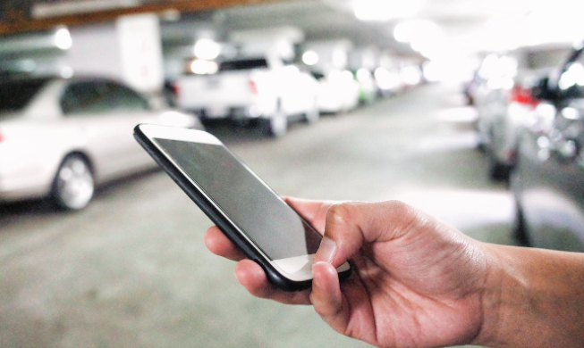 Someone ordering a self-driving car on their phone | MAS Law